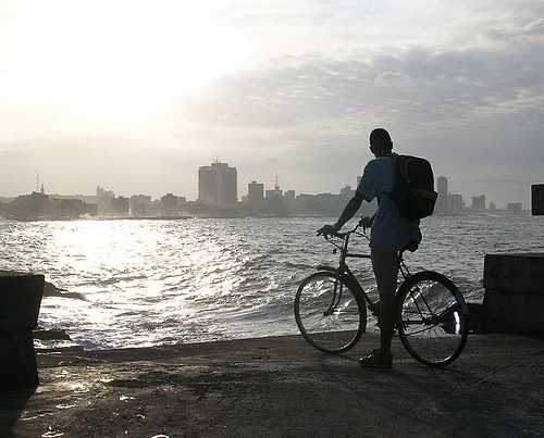 Ciclista aprecia o Malecón ao cair da tarde